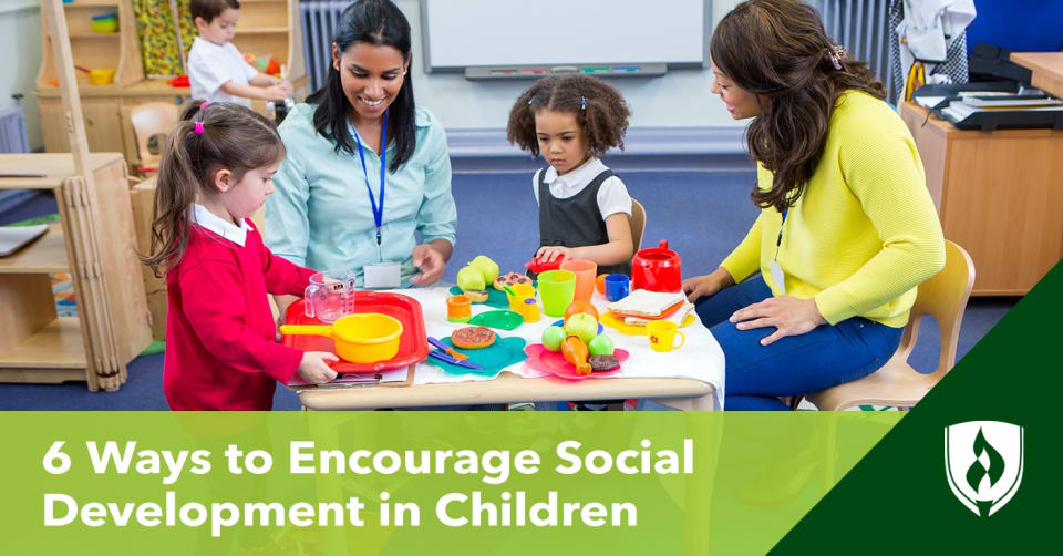 两个孩子和两个老师在桌子旁玩耍的照片，代表了儿童的社会发展