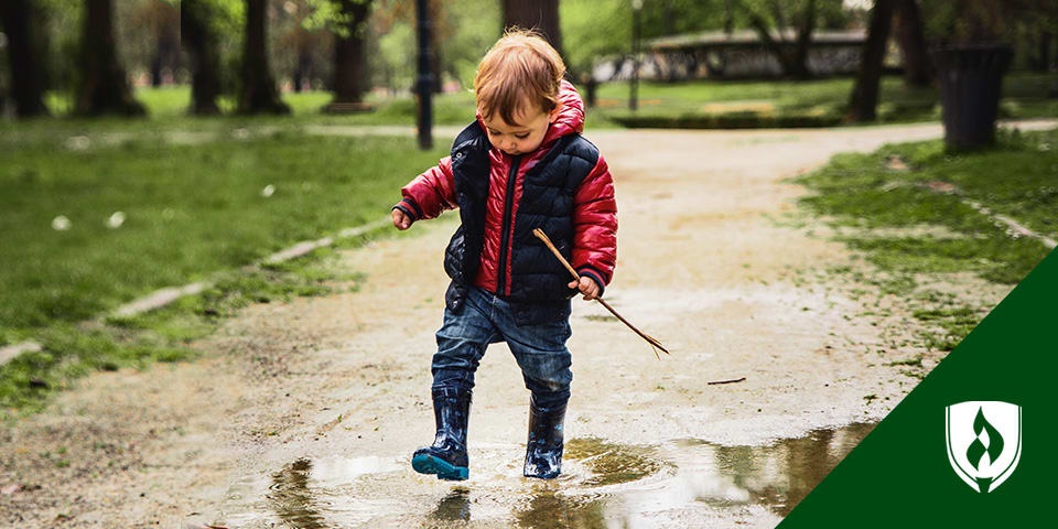 在雨中玩耍的学龄前儿童的照片，代表学前儿童的幼儿活动