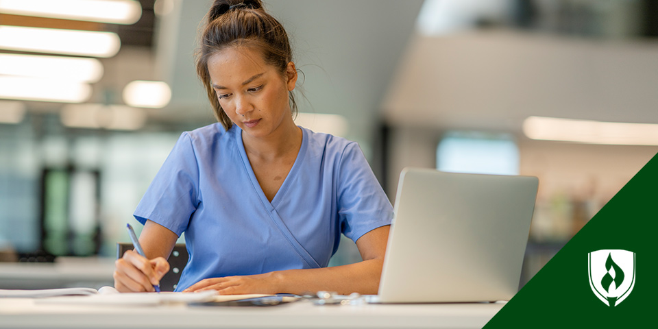 photo of a nursing student doing homework in their scrubs representing is nursing school worth it