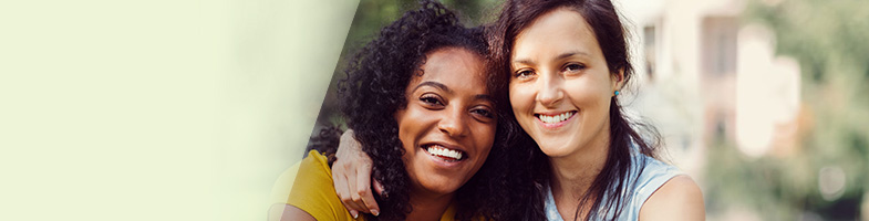 Smiling females with arms around shoulders