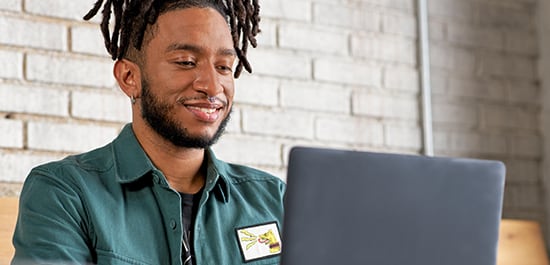 Male graphic design student on laptop tile image